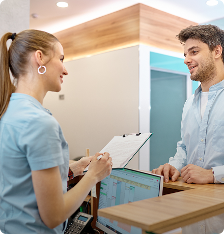 Patient receiving an appointment reminder from a staff member in a medical office.