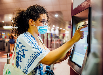 Individual checking in at a self-service kiosk for health certification.