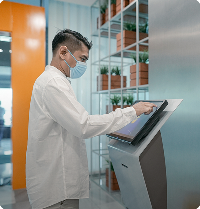 A patient using a self-service kiosk for check-in at a healthcare facility.